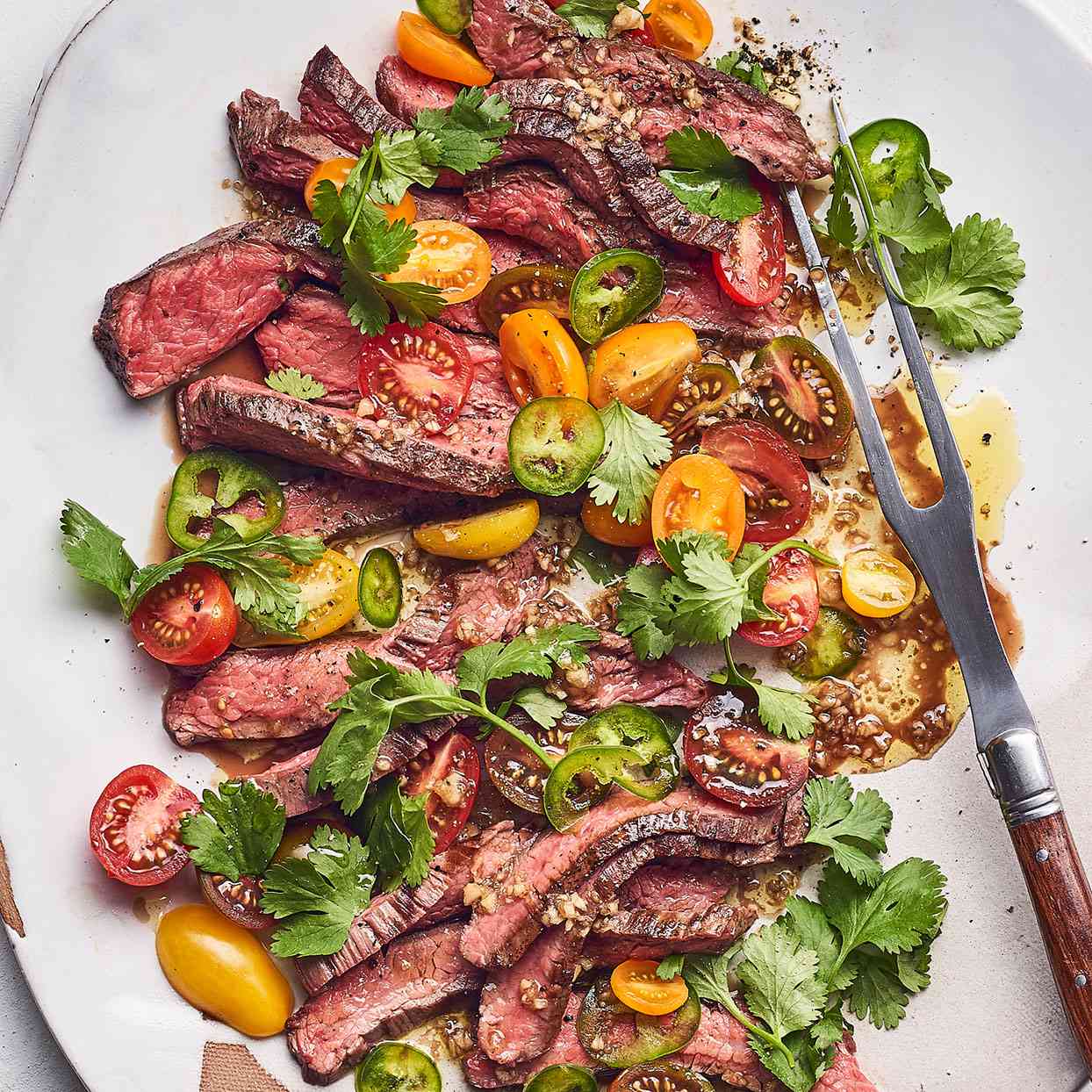 Image of premium highland beef, flank steak, cooked with tomoatoes